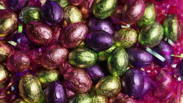 Rotating shot of colorful Easter candies on a bed of easter grass - EASTER alt