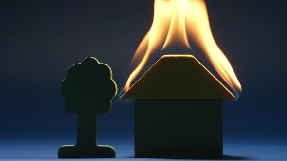 Burning toy house in a dark