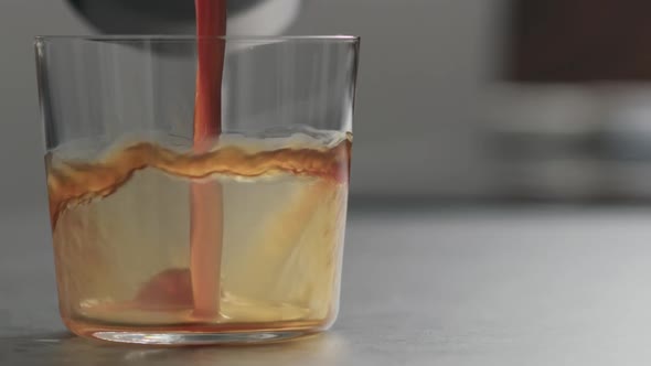 Slow Motion Pour Coffee in Tumbler Glass on Concrete Countertop with Copy Space alt