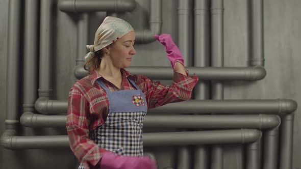 Housewife in Rubber Gloves Showing Muscular Strength alt