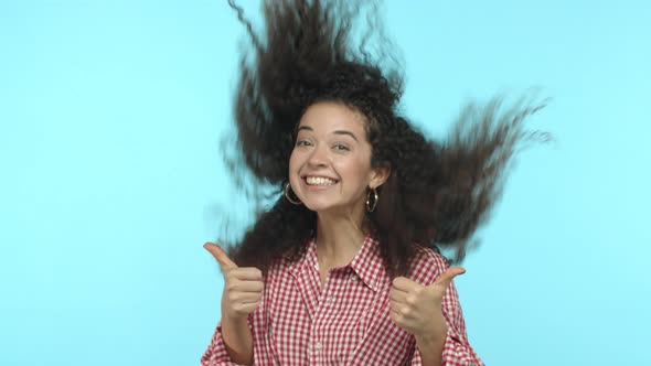 Slow Motion of Cheerful Young Woman with Long Curly Hair Jumping and Appear on Blue Background with