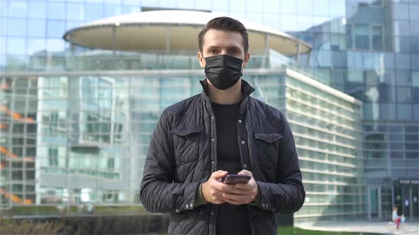 Man Wearing a Mask on a Background of a Modern Building, alt