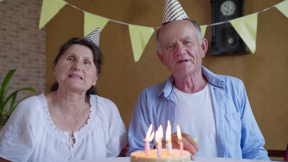 Celebration Remote, Elderly Couple Old Parents with Caps and Balloons Clap Their Hands and Look at