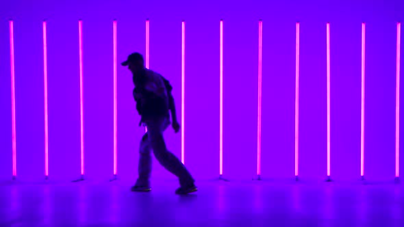 Cool Young Guy Breakdancer Dancing Hip Hop in Colorful Background with Neon Lamps alt