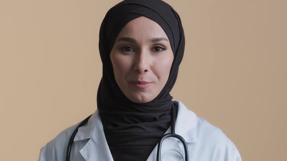 Young Muslim Professional Woman Female Doctor Physician in Hijab White Medical Uniform Consulting alt