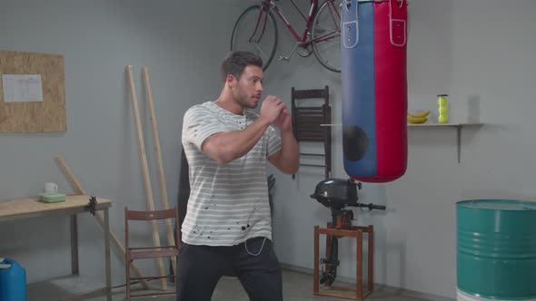 Slow Motion, Man Practicing Tricks on a Punching Bag  alt