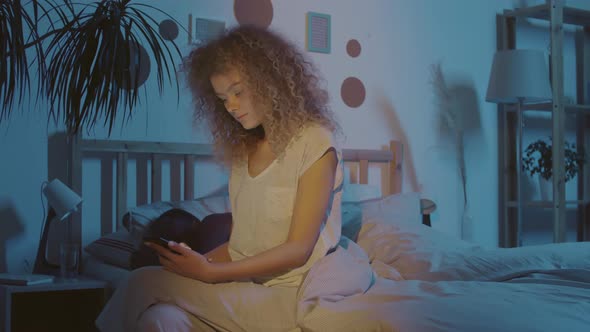 Wife Using Mobile Phone while Husband Sleeping alt