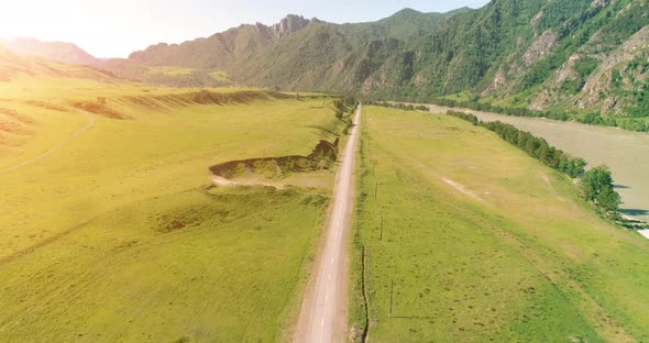Aerial Rural Mountain Road and Meadow at Sunny Summer Morning. Asphalt Highway and River alt