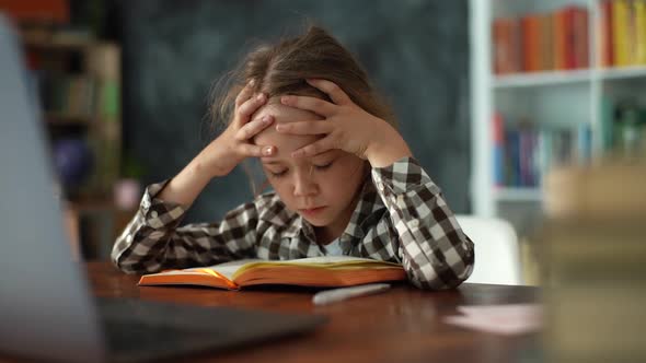 Closeup of Exhausted Upset Primary Child School Girl Banging Head Against Table Writing Difficult alt