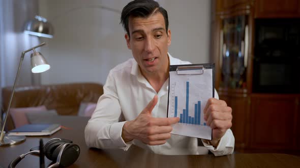 Portrait of Serious Middle Eastern Expert Showing Graphs Talking Looking at Camera alt