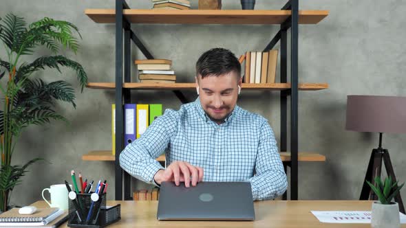Smiling man financial analyst broker sitting on chair at desk using laptop alt