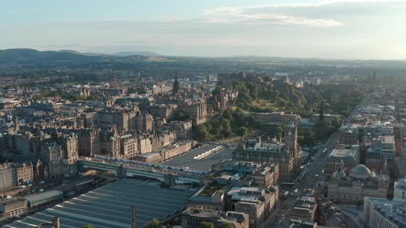 Dolly back drone shot of Central Edinburgh Princes street Calton hill at sunset alt