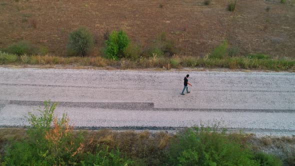Lonely Young Man Walking On Road alt