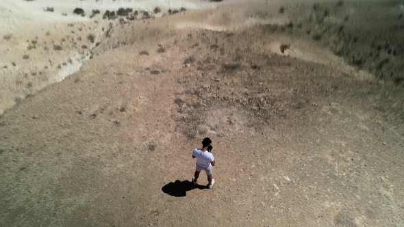 Aerial View Footage of a Man Walking Forward in the Desert Alone