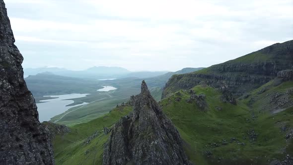 advance drone shot between old man of storr rock formations in isle of skye scotland. Green mountain alt