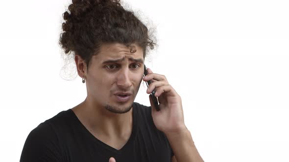 Closeup of Serious Handsome Guy with Beard and Curly Hair Explain Something During Phone Call alt