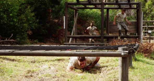 Military people crawling under the hurdles during obstacle course 4k