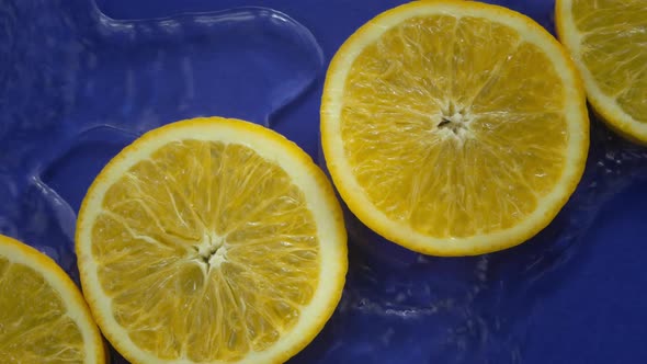 Blue Water Flowing Slow Mo Around Citrus Orange Slices