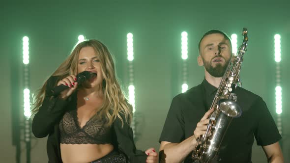 Musical Group Band of Singer Woman Saxophonist Sax Man Playing Music Song Performing on Stage alt