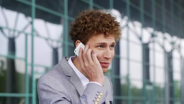 Close Up Slow Motion Business Man in Suit Answer Phone Call on Mobile Cellphone Standing on Street