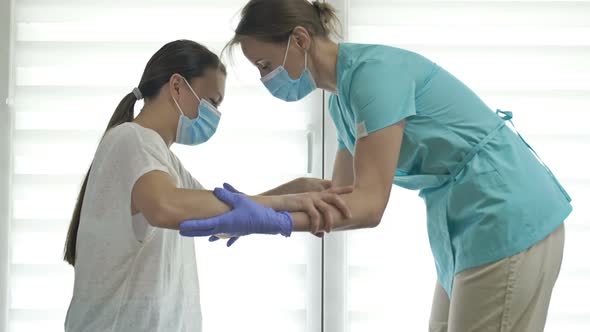 Doctor or Nurse is Helping an Female Patient to Get to Her Feet alt