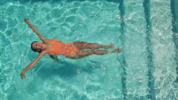 Woman Is Floating on Back in Pool alt