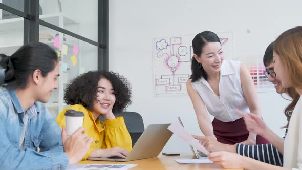 Handheld slow footage of Group of asian young creative happy entrepreneurs in a business meeting. alt