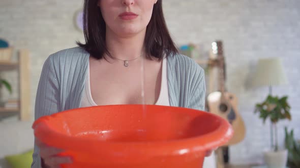 Close Up of a Woman Using a Bucket Catches Water Drops From the Ceiling alt