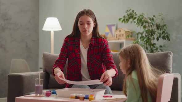Elder Sister Covers Tray with Paint for Ebru Art with Girl alt