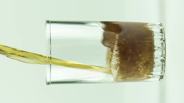 Vertical Video Cola is Poured Into Glass Full of Bubbles and Foam Isolated on White Background