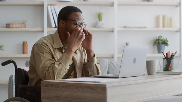Tired Handicapped Man In Wheelchair At Laptop Rubbing Eyes Indoor alt