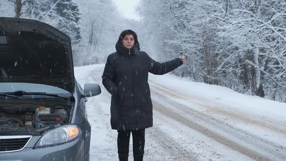 Woman at the Background of Broken Car Trying Hitchhiking Other Cars