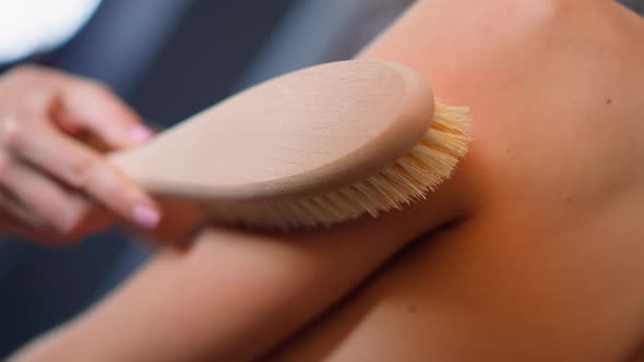Woman Makes Massage with Anticellulite Brush on Shoulder alt