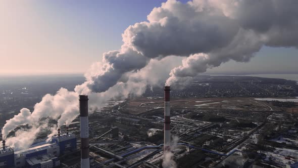 Industrial emissions of smoke from factory pipes in industrial zone alt