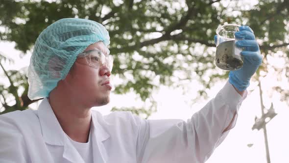 Ecologist samples of factory wastewater a test tube for analysis in lab. alt