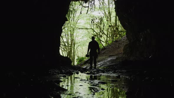 Man Inside a Cave Against Jungle Rainforest