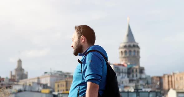 A Worried Young Man While Smoking Cigarette in front of Galata Tower in Istanbul, Turkey.
