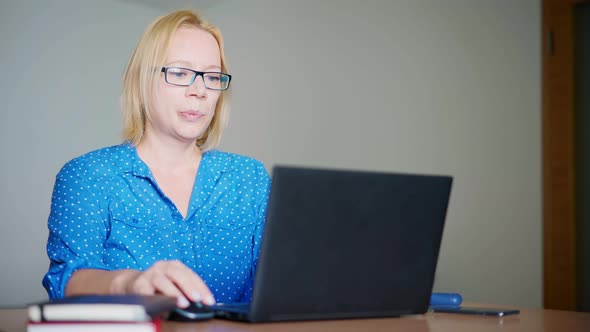 A Happy Blond Woman Finishing Her Workday at Home alt