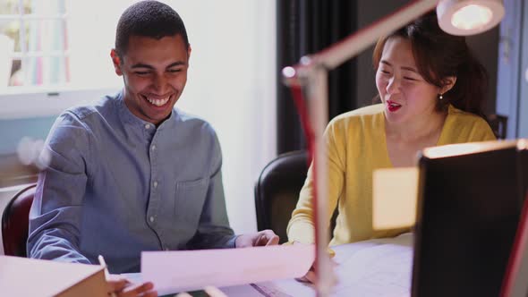 Two happy young business people talking in the office alt