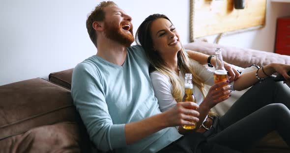 Beautiful Couple in Love Watching Tv and Drinking