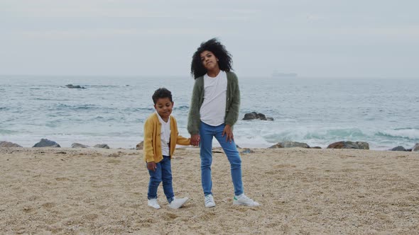Two Funny Siblings Are Standing On Beach