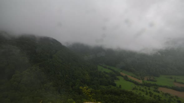 Timelapse shot with a lot of fog and dense clouds. The clouds areing very fast up the mountain. In t alt