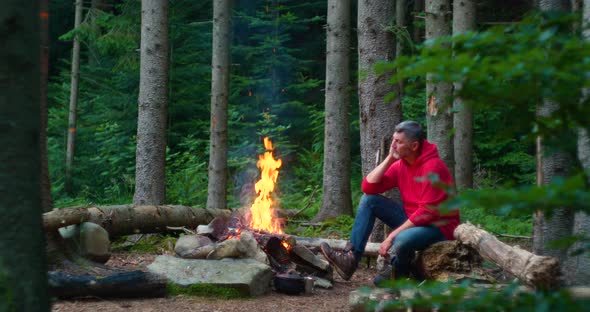 Bearded Male Tourist Near Campfire in the Forest alt