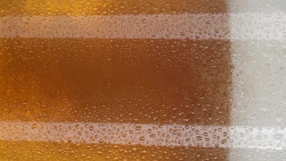 pour beer in glass close up and rotation. glass of beer with foam. vertical video. 4K UHD video alt