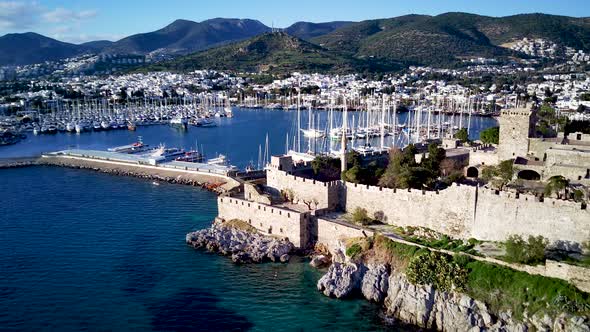 View from drone on full of yachts Bodrum harbour and ancient Kalesi castle in Mugla in Turkey