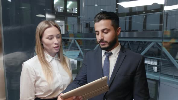 Coworkers in elevator with tablet computer