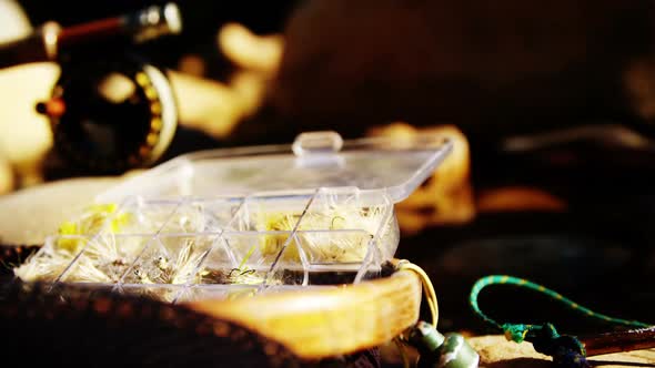 Fishing baits, fishing rod and net on rock alt