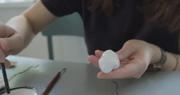 Woman Making Doll Ceramic Part Close Up. Female Sitting and Creating Ear for Doll at Home at Table alt