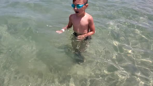 The Boy is Resting During the Summer Holidays Having Fun Swimming in the Sea on a Sunny Day