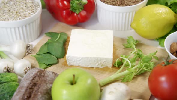 Appetizing Feta Cheese on a Wooden Board Surrounded By Many Different Vegetables